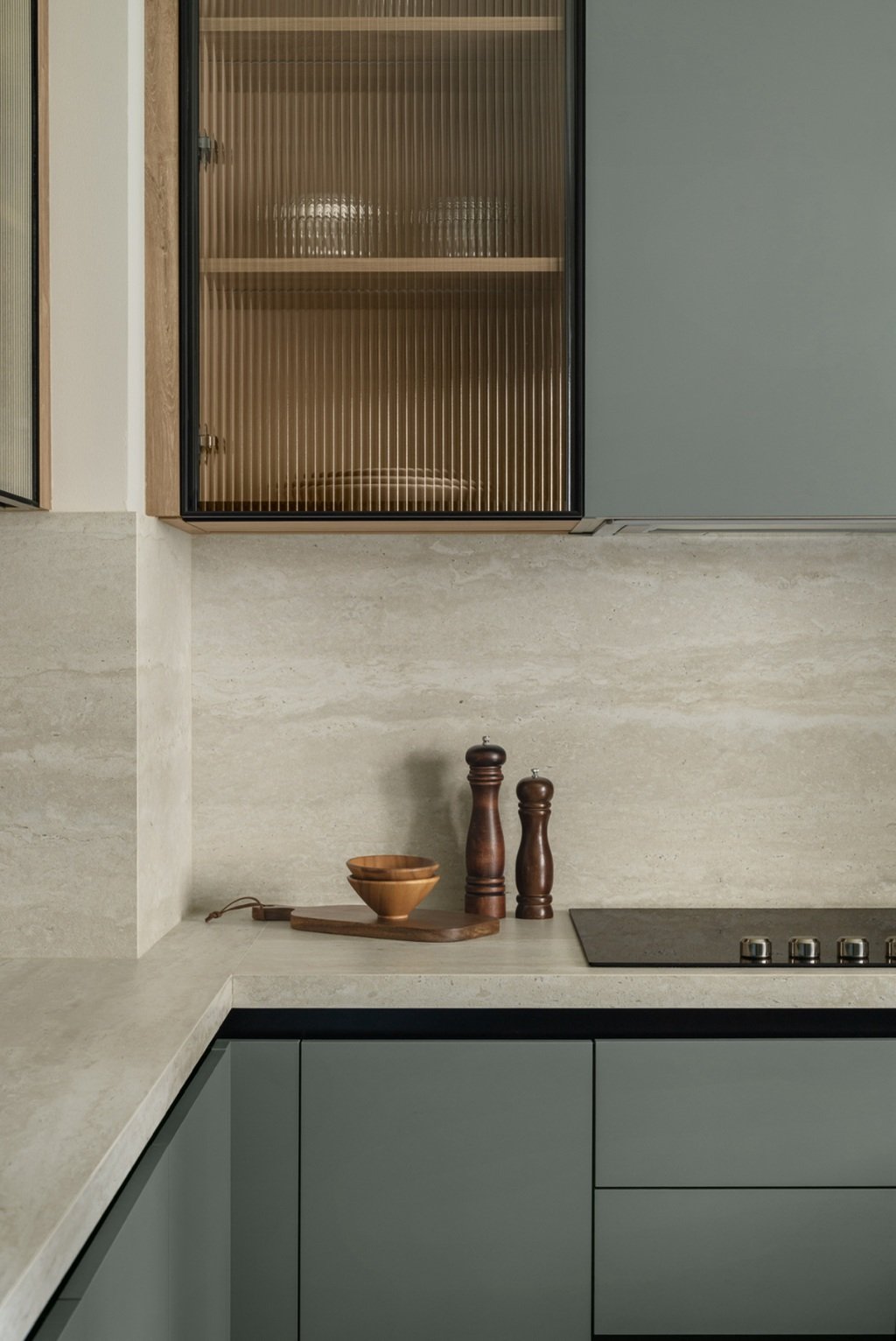 Studio detail — sage cabinetry, fluted glass, travertine